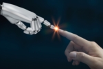 A robotic hand and a human hand reaching towards each other with their index fingers touching, creating a small light spark at the point of contact, symbolizing human-technology connection.